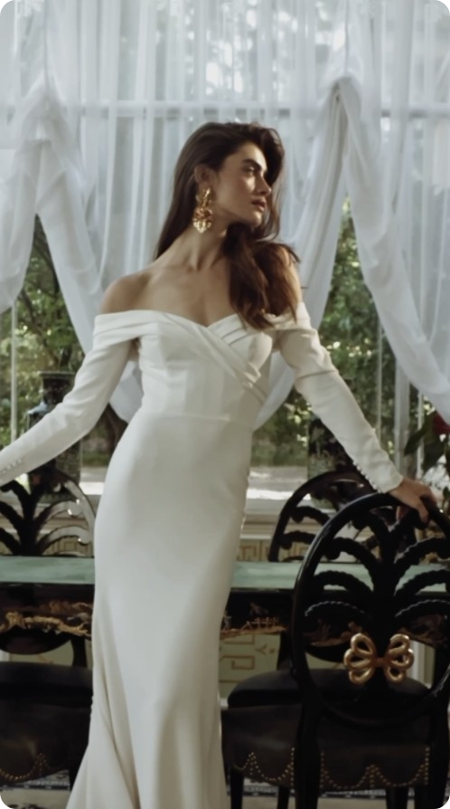 Photo of the model posing and wearing a white bridal gown